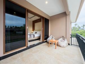a bedroom with a bed on a balcony at Airindah Villa in Gili Islands