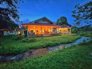 a home with a river in front of it at Creek Cottage Chaeson in Ban Mun Thung