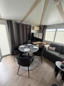 a living room with a couch and a table and chairs at Seacottage Blankenberge-Wenduine in De Haan +9 photos