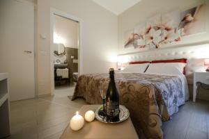 馬泰拉的住宿－In Bocca ai Sassi，一间卧室配有一张床,桌子上备有一瓶葡萄酒