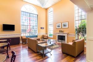 a living room with chairs tables and a fireplace at Quality Suites Lubbock Southwest in Lubbock