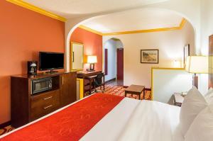a hotel room with a bed and a flat screen tv at Quality Suites Lubbock Southwest in Lubbock +36 photos
