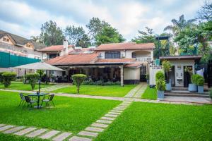a house with a green yard with a table at Cozy Stead Hotel - Garden House, Gigiri in Nairobi
