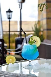 a blue drink with a lime on a table at TJ's Boutique Hotel in Eldoret