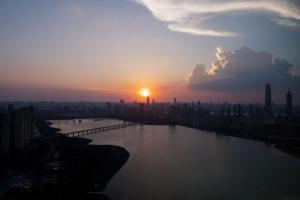a sunset over a river with a city at Wuhan Marriott Hotel Wuchang in Wuhan