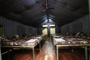 a room with a row of beds and a ceiling at Nivant Agro Experience in Gorhe