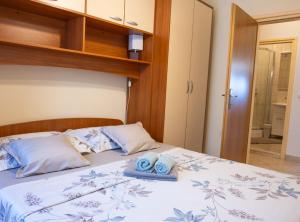 a bedroom with a bed with two towels on it at Apartments Sea Line in Prigradica