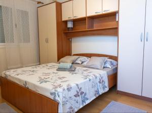 a bedroom with a bed with a wooden headboard at Apartments Sea Line in Prigradica