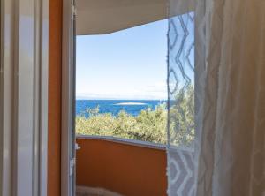 a window in a room with a view of the ocean at Apartments Sea Line in Prigradica +36 photos