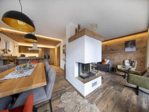 a living room with a fireplace and a table at Mountain Wellness stay in Neukirchen in Neukirchen am Großvenediger