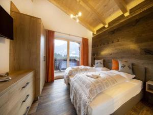 a bedroom with two beds and a large window at Mountain Wellness stay in Neukirchen in Neukirchen am Großvenediger