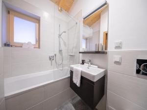 a white bathroom with a sink and a shower at Mountain Wellness stay in Neukirchen in Neukirchen am Großvenediger +40 photos