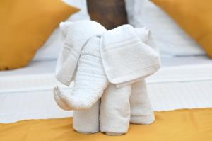 a white towel stuffed elephant sitting on a bed at Green View Safari Resort in Udawalawe