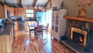 a kitchen with a fireplace and a table and chairs at Rocky Mountain Panorama Cabin in Estes Park