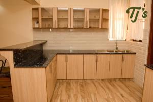 a kitchen with wooden cabinets and a counter top at TJ's Boutique Hotel in Eldoret +76 photos