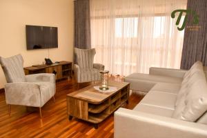 a living room with a couch and chairs and a table at TJ's Boutique Hotel in Eldoret