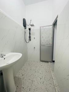a bathroom with a sink and a phone on the wall at Golden Paradise Transit Hotel in Katunayaka