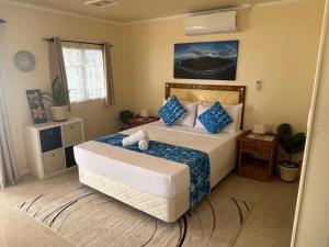 a bedroom with a bed with blue and white pillows at Tia Maria Retreat in Rarotonga