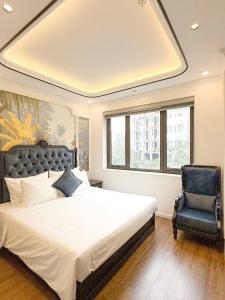 a bedroom with a large bed and a blue chair at Royal Hotel Lâm Hạ in Hanoi