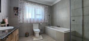 a bathroom with a tub and a toilet and a sink at Ongersfontein gasteplaas in Richmond