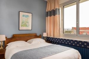 a bedroom with a bed and a window at Hotel Aguado in Dieppe