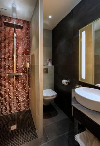 a bathroom with a sink and a toilet and a shower at Hotel Aguado in Dieppe