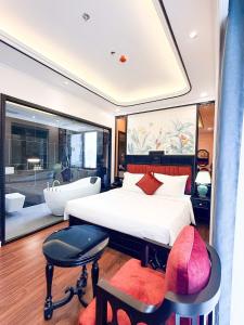 a bedroom with a large white bed and a tub at Royal Hotel Lâm Hạ in Hanoi