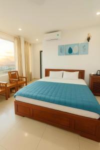 a bedroom with a large bed with a blue blanket at Manh Vuong Buotique Hotel in Cat Ba