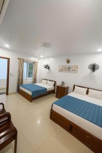 a bedroom with two beds and a window at Manh Vuong Buotique Hotel in Cat Ba +10 photos