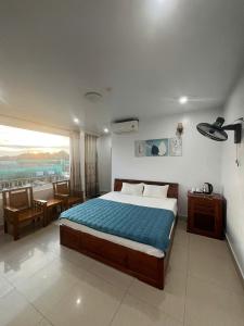 a bedroom with a bed and a view of the ocean at Manh Vuong Buotique Hotel in Cat Ba