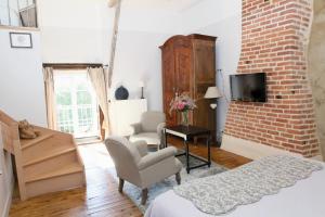 a bedroom with a bed and a brick wall at La Gentilhommière in Chantepie