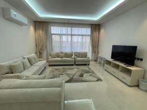 a living room with couches and a flat screen tv at شقة ياسمين الفندقية in Medina