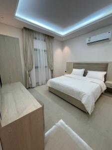 a bedroom with a large white bed and curtains at شقة ياسمين الفندقية in Medina