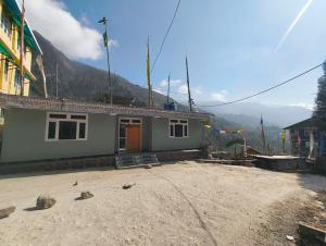 a small house in the middle of a dirt lot at Mayal Lyang Lachung in Mangan