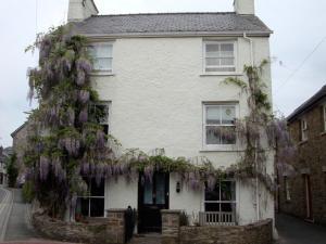 a white house with wisteria on the side of it at Half Moon House in Hay-on-Wye