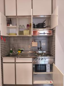 a kitchen with white cabinets and a stainless steel stove at Il Chicco di Arianna in Torre del Lago Puccini