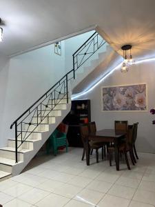 a dining room with a table and a staircase at Villa Bukit Asri Berastagi in Berastagi +1 photo