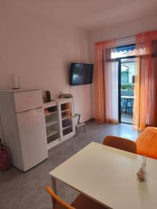 a living room with a white refrigerator and a table at Il Chicco di Arianna in Torre del Lago Puccini