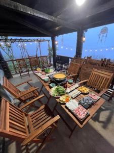 a table with plates of food on it with chairs at Charming Home Tà Xùa in Bắc Yên