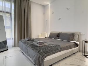 a bedroom with a bed with towels on it at SWIFT Suites Limassol in Limassol