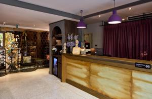 a restaurant with a bar with purple pendant lights at The Weekend Pattaya (Tweet Tweet Nest Pattaya) in Pattaya