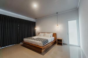 a bedroom with a bed and a large window at Taman Villa Kelating in Krambitan