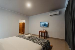 a bedroom with a bed and a television in it at Taman Villa Kelating in Krambitan