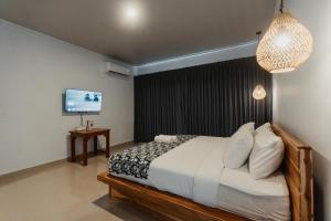 a bedroom with a large bed and a television at Taman Villa Kelating in Krambitan
