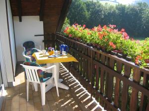 einen Tisch und Stühle auf einem Balkon mit Blumen in der Unterkunft Ferienwohnung Gerstmann in Wenholthausen