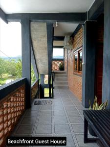 a porch of a guest house with a bench at Beachfront Guest House Pacitan in Tamperan