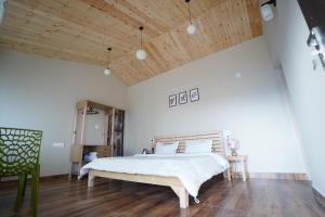 a bedroom with a large bed and a wooden ceiling at The Northern Nook in Mukteshwar