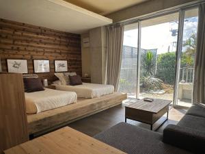 a bedroom with two beds and a large window at 海中道路を望むBBQ &ハンモック KATSUREN Blue in Uruma +73 photos