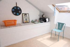 a room with a chair and a clock on the wall at Charmante chambre dans maison coloniale in Noumea