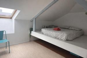 a white bedroom with a bed and a window at Charmante chambre dans maison coloniale in Noumea